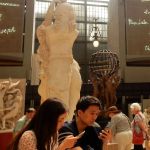 Surrounded by art, looking at their phone